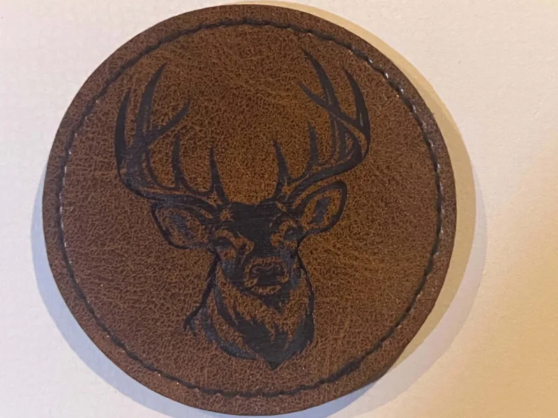 Round brown patch with an engraved antlered deer