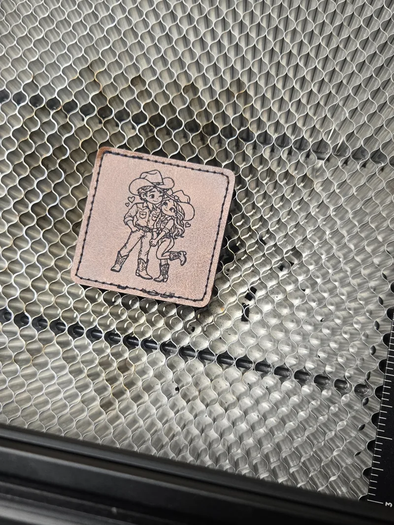 Freshly engraved illustrated patch resting on the laser’s honeycomb bed