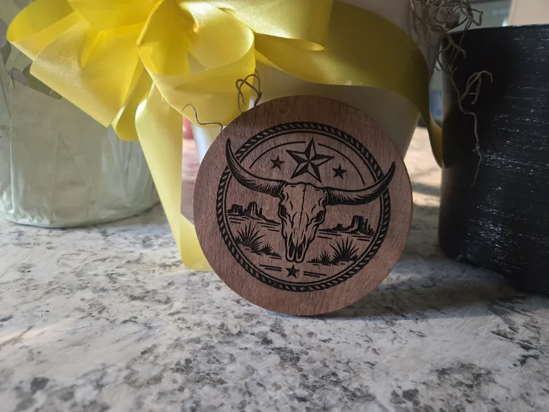 Round wooden coaster engraved with a longhorn skull, Texas star and desert landscape