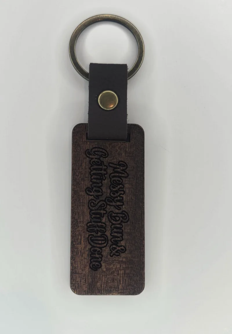 Engraved wooden keychain with a messy-bun design